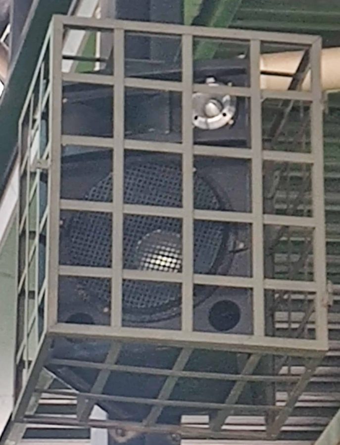 Caixa de som com gaiola instalada na estrutura metálica de uma quadra